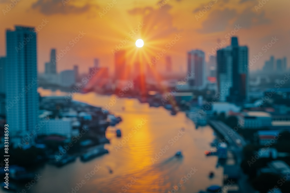 Fototapeta premium A multi-story building silhouetted against a stunning sunset, with warm orange and pink hues lighting up the sky. The scene captures the calm beauty of the evening.