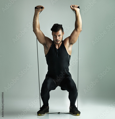 Man, exercise and portrait in resistance training, workout and gray background for health or strong muscl. Male person, athlete and balance in routine, stretch or bodybuilding in studio for wellness photo