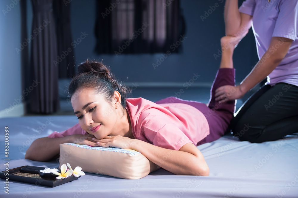 Fototapeta premium Thai heel and foot massaged to young Asian woman by masseuse