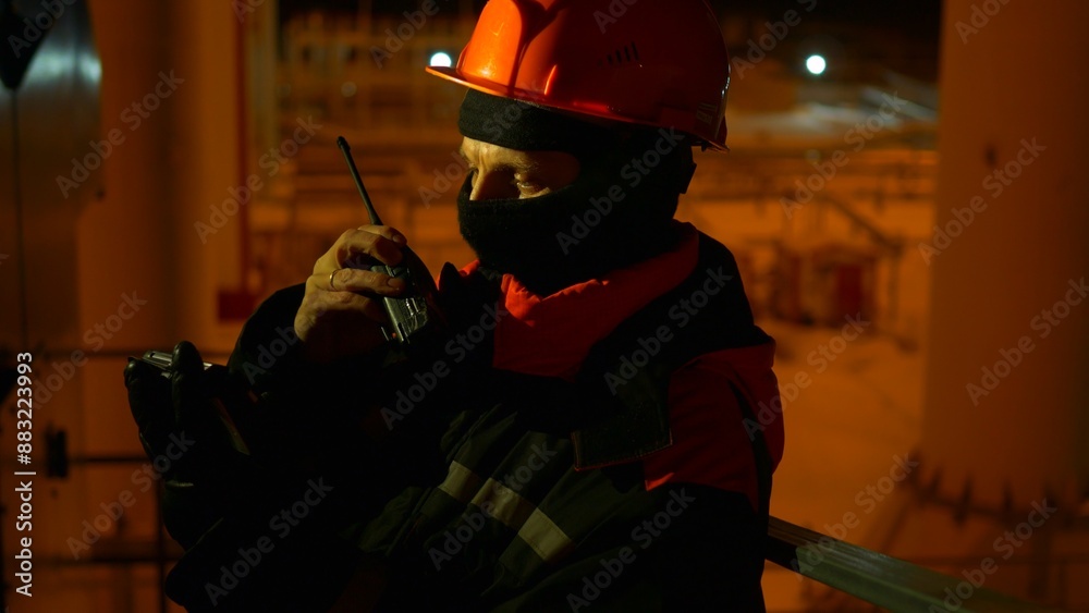 Northern shift worker uses radio to coordinate with team. Rugged, resilient worker braves harsh conditions, ensuring seamless team operations. Remote industrial site under extreme weather. Northern shift worker uses radio to coordinate with team. Rugged, resilient worker braves harsh conditions, ensuring seamless team operations. Remote industrial site under extreme weather.