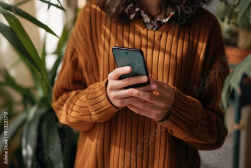 I'm typing something important Shot of an unrecognizable woman using a mobile phone indoors