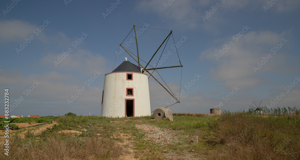 Old restored windmill in Aljezur, Portugal, against the blue sky Old restored windmill in Aljezur, Portugal, against the blue sky