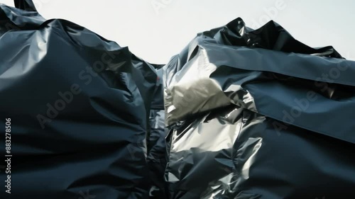 Black plastic garbage bags outdoors.