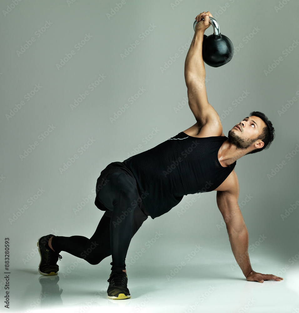 Power, balance or man lifting kettlebell for muscle health or explosive strength in studio on grey background. Workout, flexible or Indian bodybuilder with weight for fitness training or exercise Power, balance or man lifting kettlebell for muscle health or explosive strength in studio on grey background. Workout, flexible or Indian bodybuilder with weight for fitness training or exercise