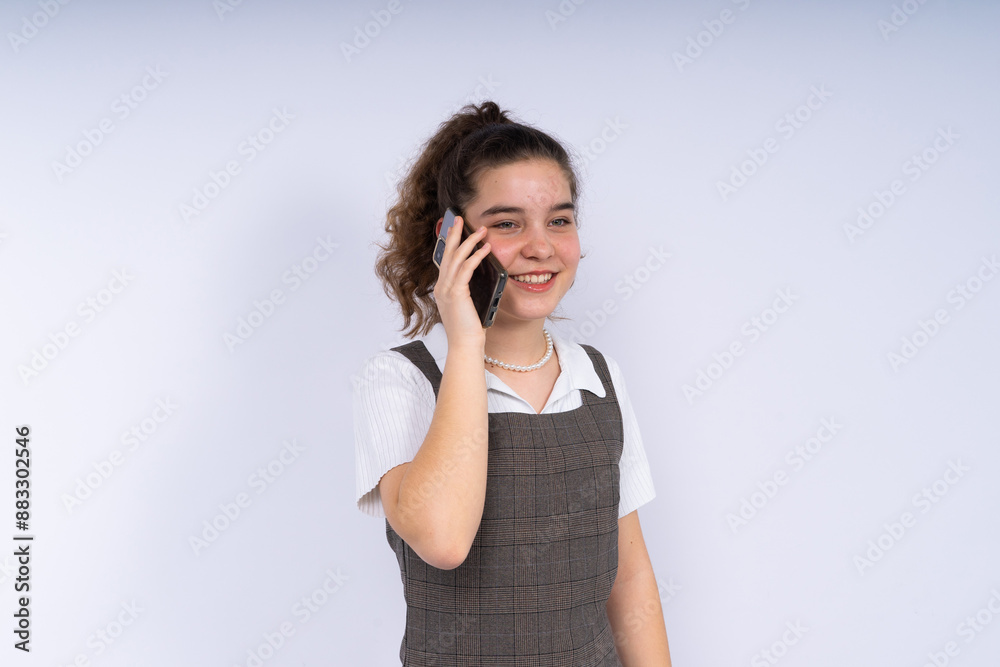 Happy beautiful young woman teenager with long curly hair holding mobile phone Happy beautiful young woman teenager with long curly hair holding mobile phone