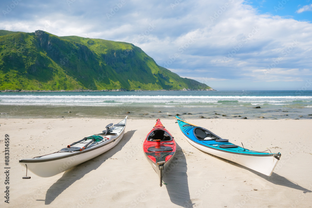 Kayaks on a sandy shore. Water sports. Active recreation and travel in summer time. Norway. Nature in fjords. Panoramic view. Traveling on a Norwegian fjord. Scandinavia Kayaks on a sandy shore. Water sports. Active recreation and travel in summer time. Norway. Nature in fjords. Panoramic view. Traveling on a Norwegian fjord. Scandinavia