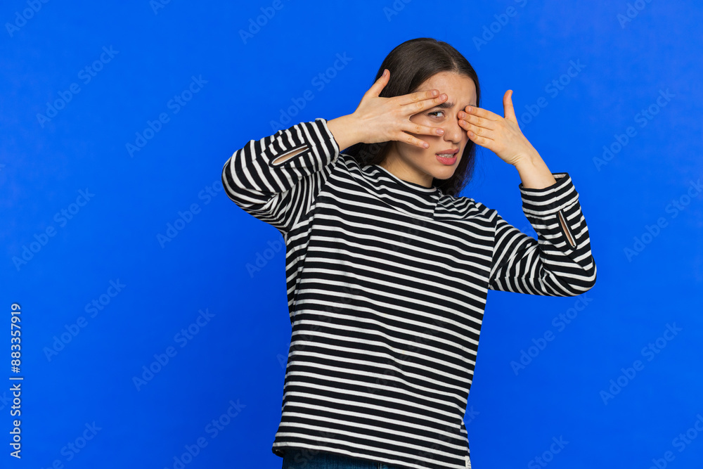 Don't want to look at this, awful. Afraid shocked Caucasian woman in striped blouse closing eyes with hand showing stop gesture, confused shy scared reject to watch. Girl isolated on blue background Don't want to look at this, awful. Afraid shocked Caucasian woman in striped blouse closing eyes with hand showing stop gesture, confused shy scared reject to watch. Girl isolated on blue background