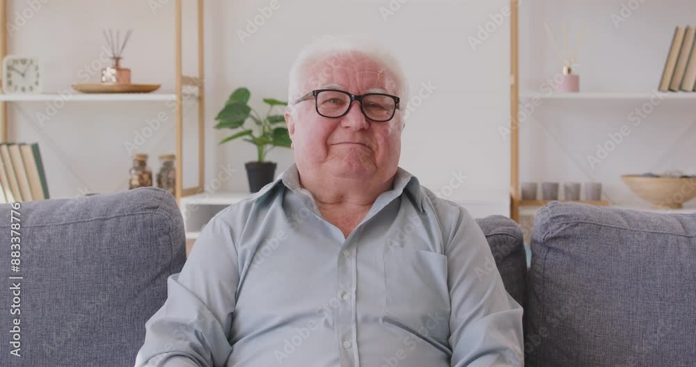 Senior man greets doctor online, indicating pain in head and heart and asks for prescription. Man in need of treatment is sitting on sofa in front of web camera and talking to doctor via video call. Senior man greets doctor online, indicating pain in head and heart and asks for prescription. Man in need of treatment is sitting on sofa in front of web camera and talking to doctor via video call.