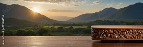 Wooden surface with intricate carvings rests in foreground, showcasing scenic view of mountains and golden sunset © yevhen89