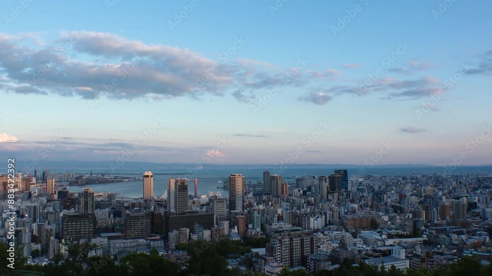 KOBE, HYOGO, JAPAN -JUN 2024 : Aerial high angle view of Kobe city and Kobe port in sunset. View of buildings and street around Kobe port tower and Sannomiya station. 4K time lapse shot, dusk to night KOBE, HYOGO, JAPAN -JUN 2024 : Aerial high angle view of Kobe city and Kobe port in sunset. View of buildings and street around Kobe port tower and Sannomiya station. 4K time lapse shot, dusk to night