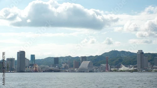 KOBE, HYOGO, JAPAN - JUNE 2024 : Scenery around Kobe port in daytime. View of buildings at Meriken park and Sannomiya downtown area. Travel and tourism concept video. 4K time lapse shot. photo