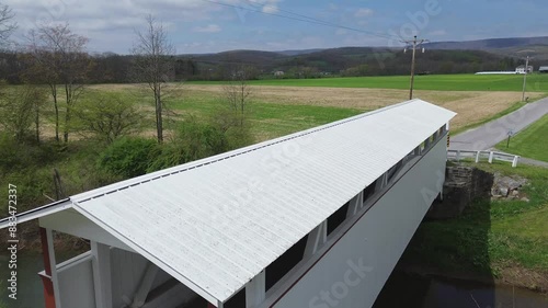 Ryot covered bridge near New Paris, PA. Flyover shot that rises from a portal to reveal the farmland beyond. Shot on an early Spring day. photo