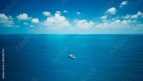 A sailboat in blue turquoise seawater near Phuket island in summer season during travel holidays vacation trip. Andaman ocean, Thailand. Tourist attraction with blue cloud sky.