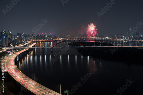 Mapo-gu, Seoul, South Korea - September 30, 2017: High angle and night view of Gangbyeon Expressway and Sogang Bridge on Han River against apartment and fireworks in the sky
 photo