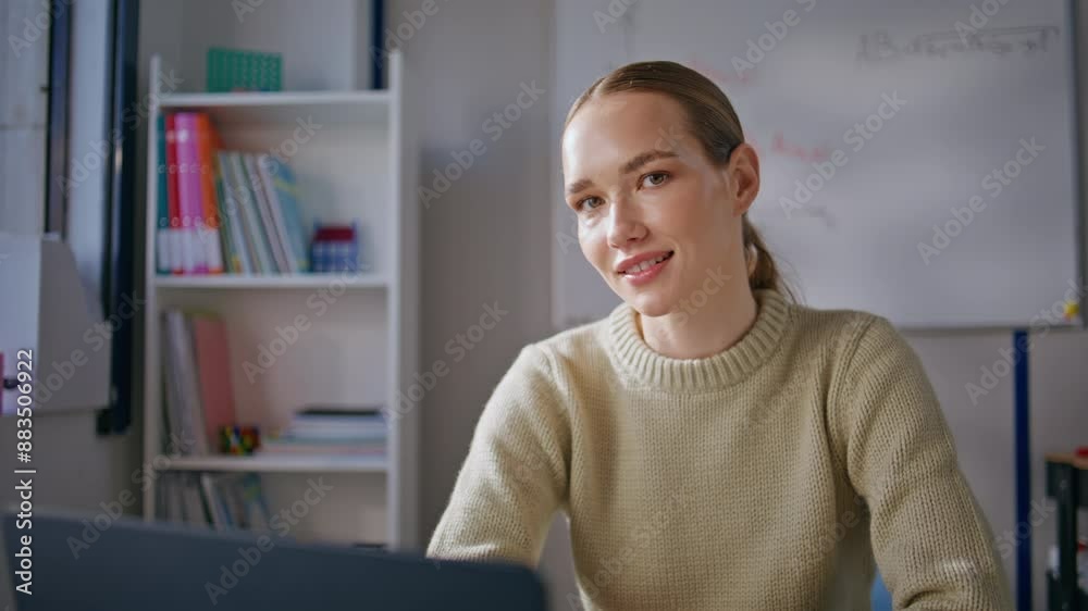 Smiling tutor looking camera sitting workplace portrait. Happy woman relaxing
