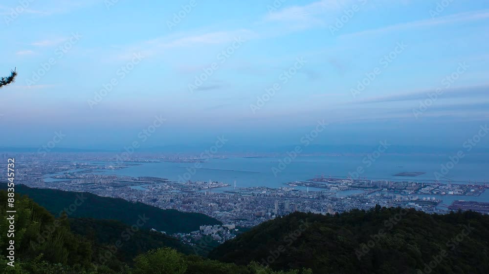 KOBE, HYOGO, JAPAN - JUN 2024 : Aerial high angle panoramic view around Kobe city, Kobe port, Osaka city and Osaka bay in sunset. View from top of Rokkosan (Mt. Rokko). Time lapse shot, day to night. KOBE, HYOGO, JAPAN - JUN 2024 : Aerial high angle panoramic view around Kobe city, Kobe port, Osaka city and Osaka bay in sunset. View from top of Rokkosan (Mt. Rokko). Time lapse shot, day to night.
