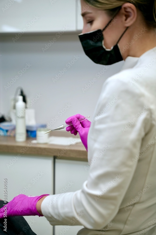 Fototapeta premium A beautician performs cosmetic procedures on a girl's face