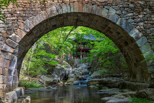 Seungju-eup, Suncheon-si, Jeollanam-do, South Korea - April 22, 2023: Spring view of Seungseongyo Bridge on water and rock of valley against pavilion at Seonamsa Temple 