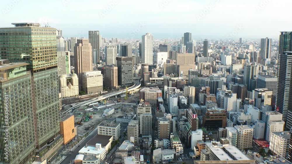 UMEDA, OSAKA, JAPAN - JUNE 2024 : Aerial view around Osaka train station in sunset. View of crowded buildings at downtown area. Urban city and business concept video. Time lapse shot, day to night. UMEDA, OSAKA, JAPAN - JUNE 2024 : Aerial view around Osaka train station in sunset. View of crowded buildings at downtown area. Urban city and business concept video. Time lapse shot, day to night.