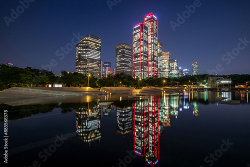 Yeongdeungpo-gu, Seoul, South Korea - June 14, 2023: Night view of water on Yeouido Mulbit Square against LG Twin Building and Park One Tower at Yeouido Hangang Park
 photo