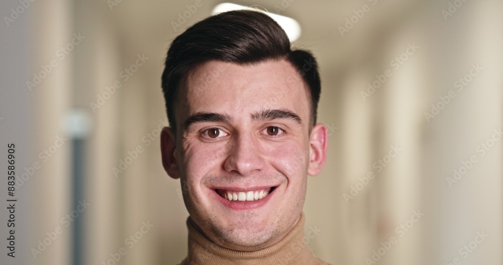 Confident Young Man with a Bright Smile in Clinic Hallway Confident Young Man with a Bright Smile in Clinic Hallway