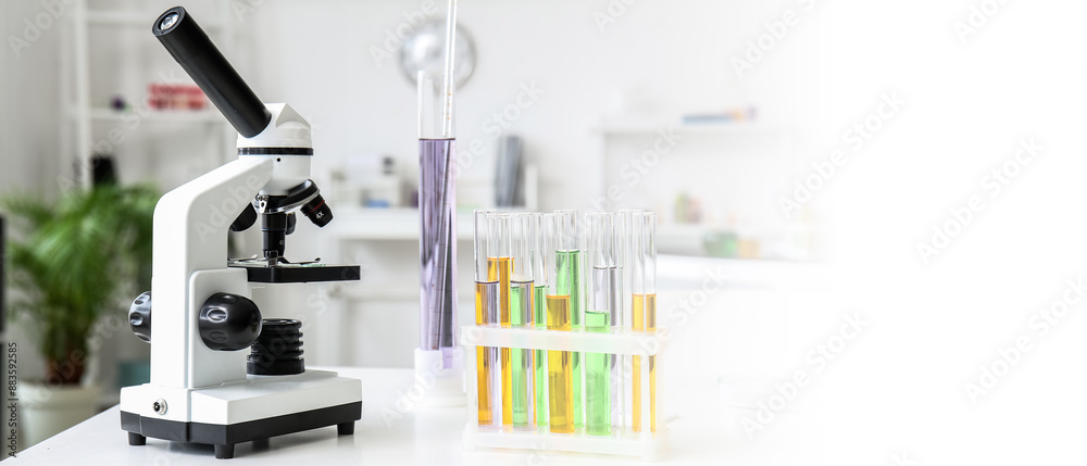 Modern microscope and test tubes on table in medical laboratory Modern microscope and test tubes on table in medical laboratory