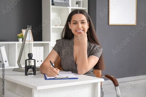 Pretty businesswoman writin...