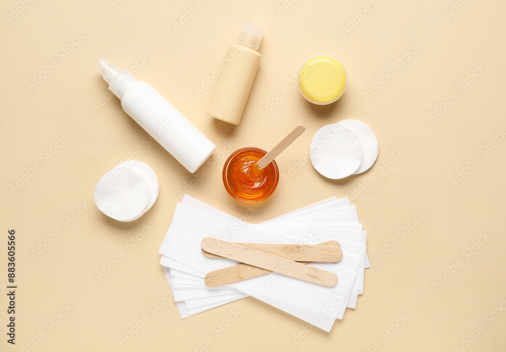Composition with sugaring paste, cotton pads and cosmetic products on beige background, top view. Epilation concept Composition with sugaring paste, cotton pads and cosmetic products on beige background, top view. Epilation concept