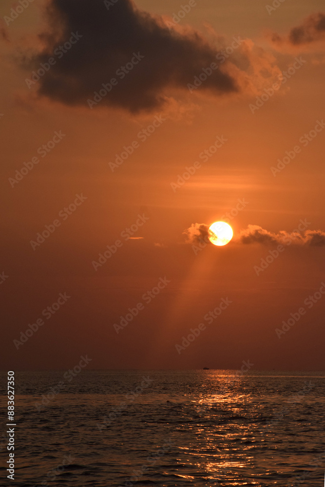 The sun looks like the moon before setting on the western horizon, has beauty with a dazzling orange light color The sun looks like the moon before setting on the western horizon, has beauty with a dazzling orange light color