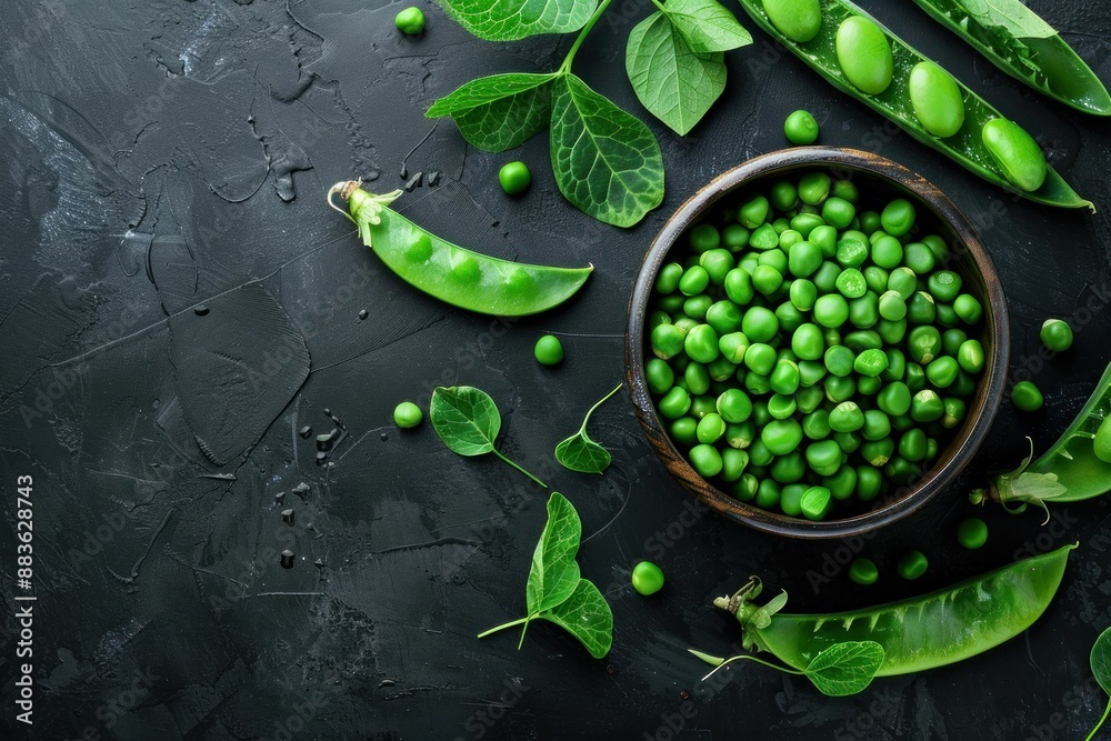 Top view of fresh green peas in a bowl on a black background with copy space for healthy food, nutrition, and cooking concepts Top view of fresh green peas in a bowl on a black background with copy space for healthy food, nutrition, and cooking concepts