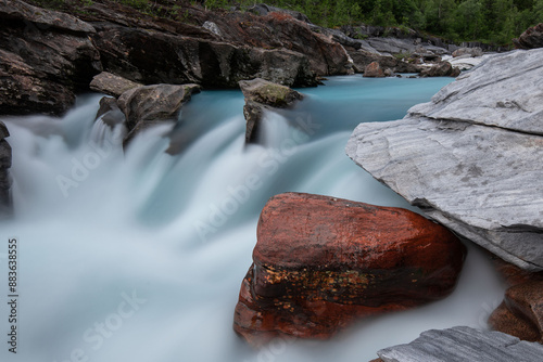 Long exposure of flowing river Marmorslottet in Rana, Helgeland, Norway. Wild stream through marble rocks turned to softness in 10 second exposure. Smooth marble rock formations with turquoise rapids photo