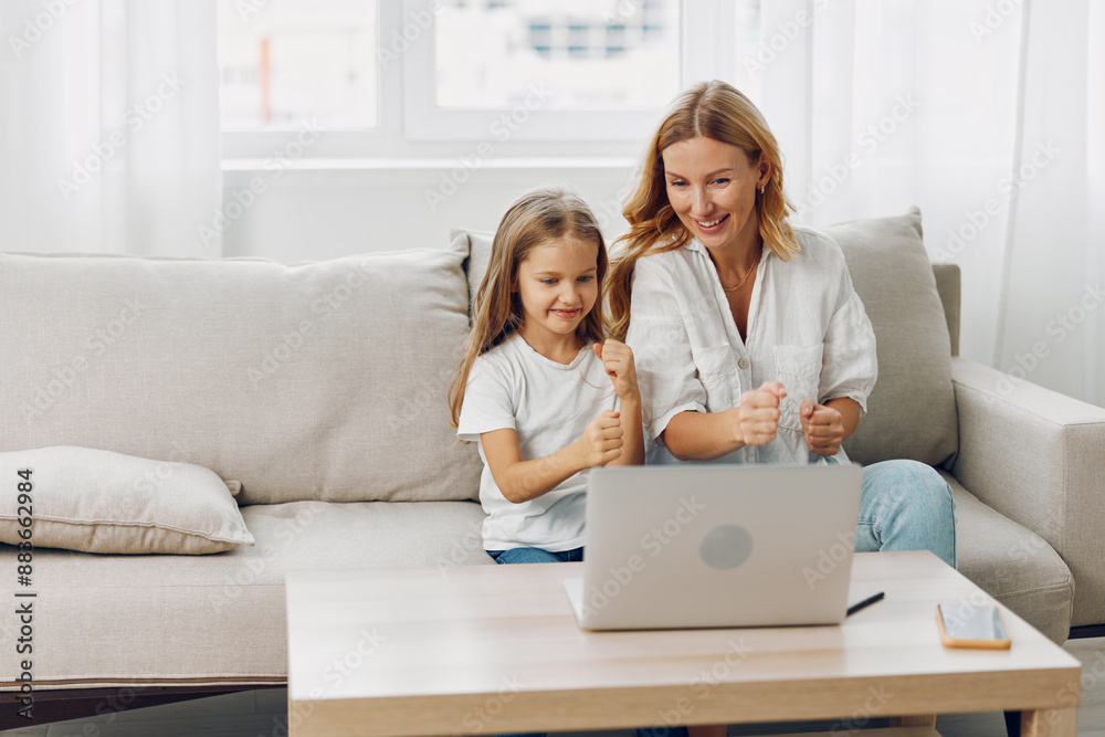Mother and daughter sharing quality time on couch while using laptop for learning and entertainment Mother and daughter sharing quality time on couch while using laptop for learning and entertainment