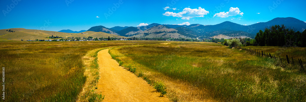 Tranquil rural dirt road curving through the prairie toward Lolo National Forest in Helena, Montana Tranquil rural dirt road curving through the prairie toward Lolo National Forest in Helena, Montana
