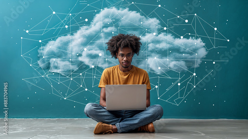 aerial view of a man sitting cross-legged and working at a laptop, with an abstract cloud and network lines in the background