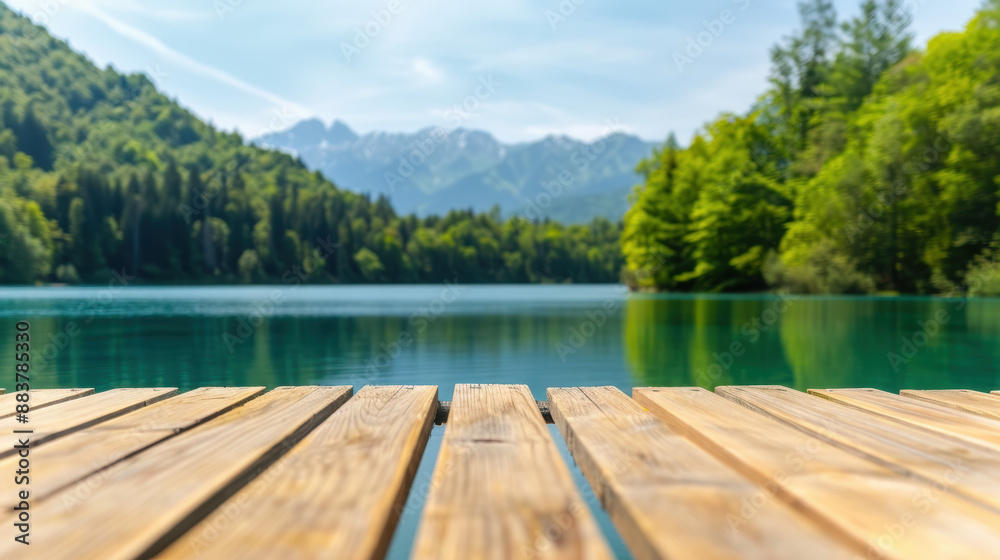 Scenic view of a serene lake and wooden dock, surrounded by lush green trees, with majestic mountains in the background under a clear sky. Scenic view of a serene lake and wooden dock, surrounded by lush green trees, with majestic mountains in the background under a clear sky.