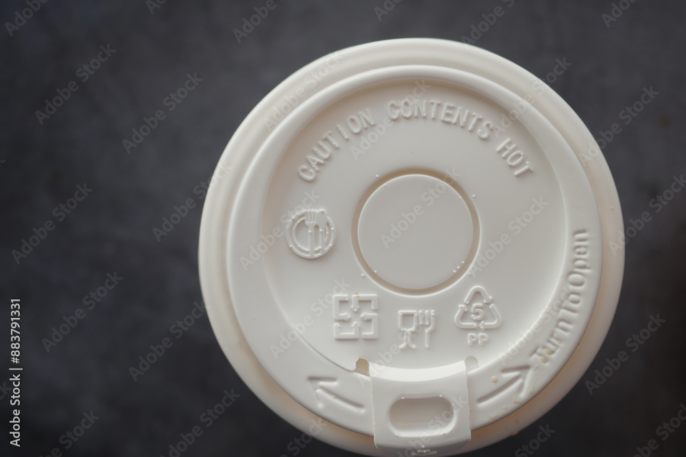 Coffee cup lid with caution hot and recycling symbols for sustainability and safety in urban Coffee cup lid with caution hot and recycling symbols for sustainability and safety in urban