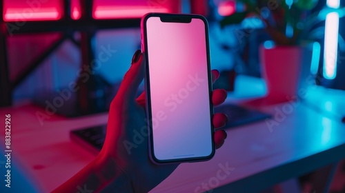 Close up Young woman holding using touch mobile phone white screen mockup,relaxes sitting in gamer room,Colorful led lights,neon light room,Back view,copy space.