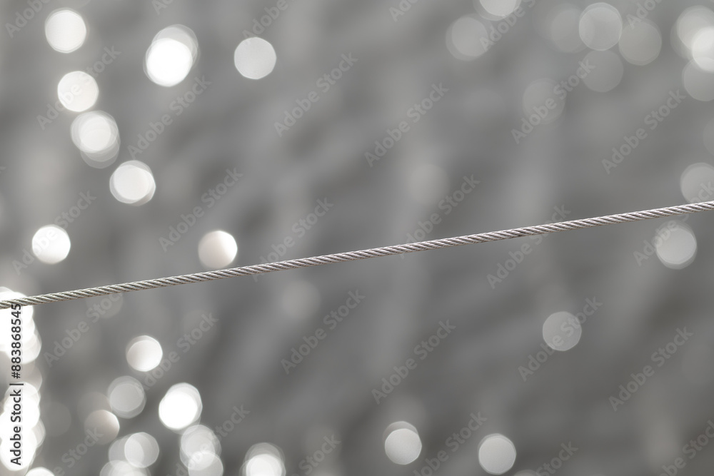 A stainless steel, acid-resistant rope with a weave on an abstract background with bokeh.