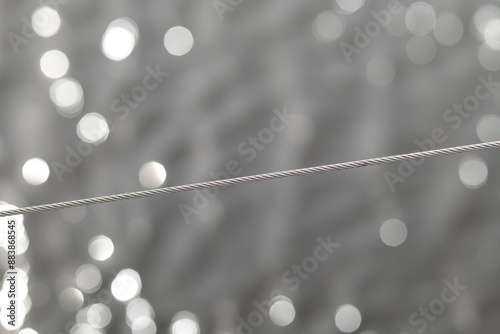 Obraz na płótnie A stainless steel, acid-resistant rope with a weave on an abstract background with bokeh. w salonie