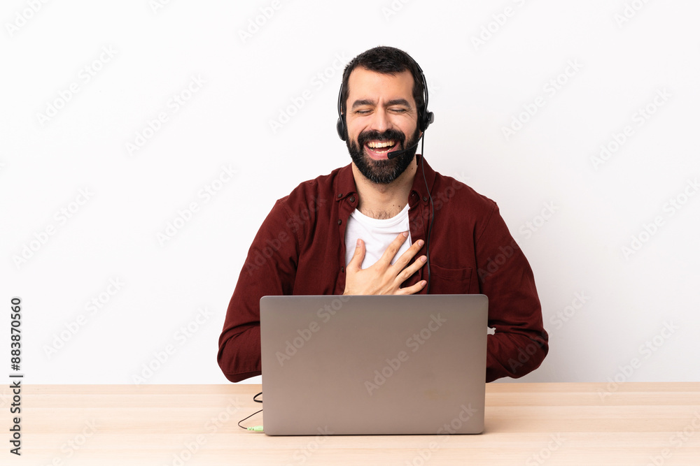 Telemarketer caucasian man working with a headset and with laptop smiling a lot. Telemarketer caucasian man working with a headset and with laptop smiling a lot.