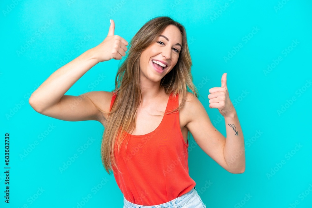 Young caucasian woman isolated on blue background giving a thumbs up gesture Young caucasian woman isolated on blue background giving a thumbs up gesture