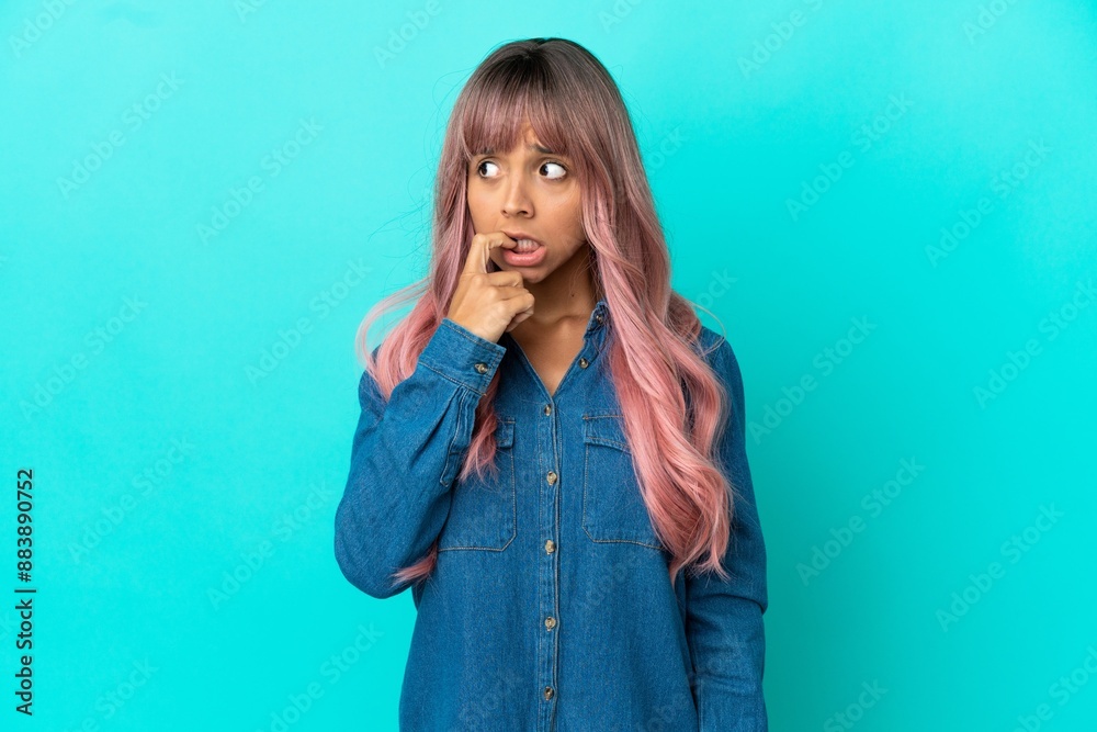 Young mixed race woman with pink hair isolated on blue background nervous and scared Young mixed race woman with pink hair isolated on blue background nervous and scared