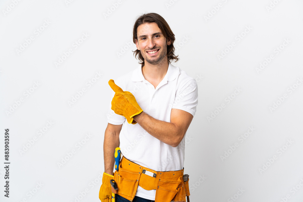 Young electrician man over isolated background pointing to the side to present a product Young electrician man over isolated background pointing to the side to present a product
