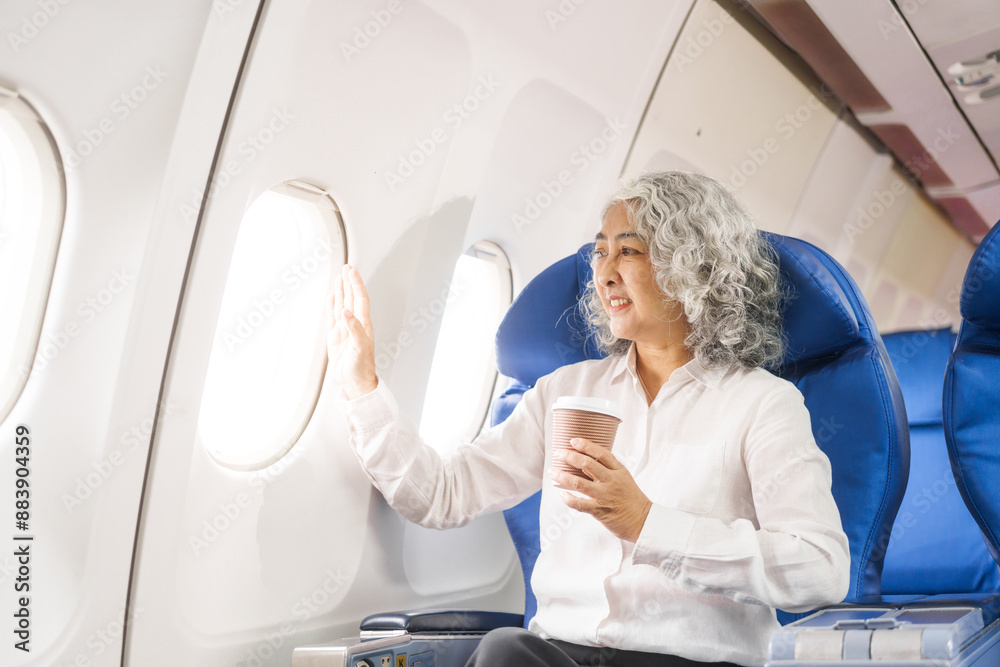 An adult woman sits by the window on a passenger plane, eagerly traveling abroad. She gazes at the clouds, anticipating new experiences and adventures in a foreign land.