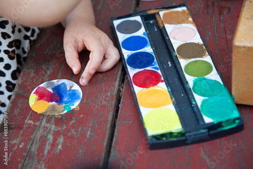 Kind zeichnet mit Farben