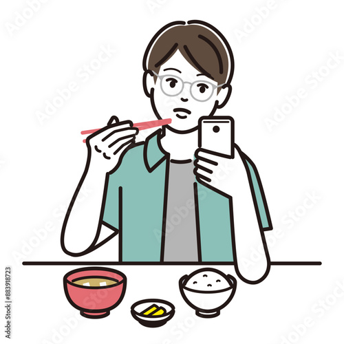 スマホを見ながら食事をする男の子