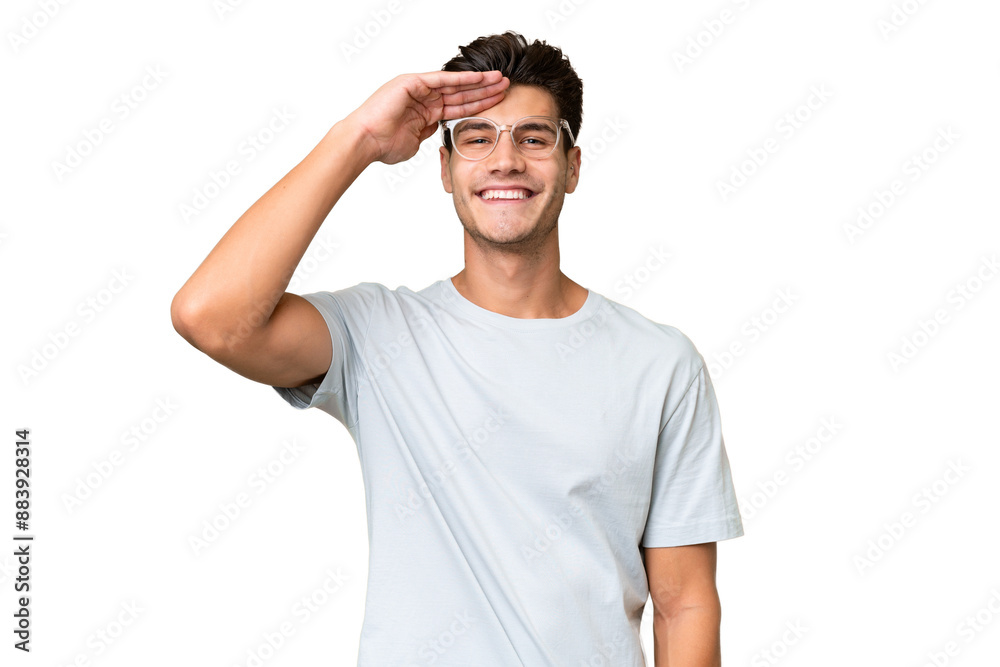 Young caucasian handsome man over isolated background saluting with hand with happy expression Young caucasian handsome man over isolated background saluting with hand with happy expression