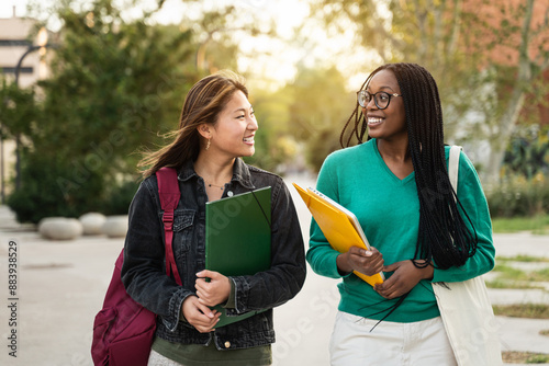 Obraz na plátně International Asian and African American student girl friends walking going back