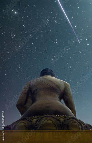 Obraz na płótnie A statue of Buddha below a starlit sky with a falling star. w salonie