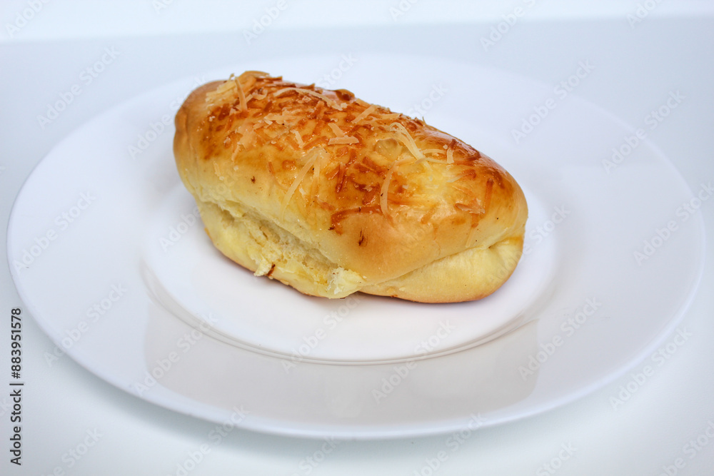 One simple bread with grated cheese on top, on white plate, isolated on white background One simple bread with grated cheese on top, on white plate, isolated on white background
